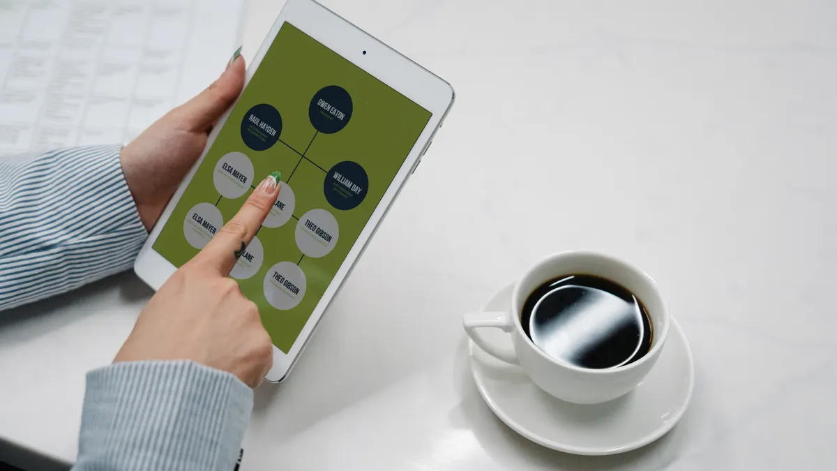 Hand using a tablet with connected workflow nodes